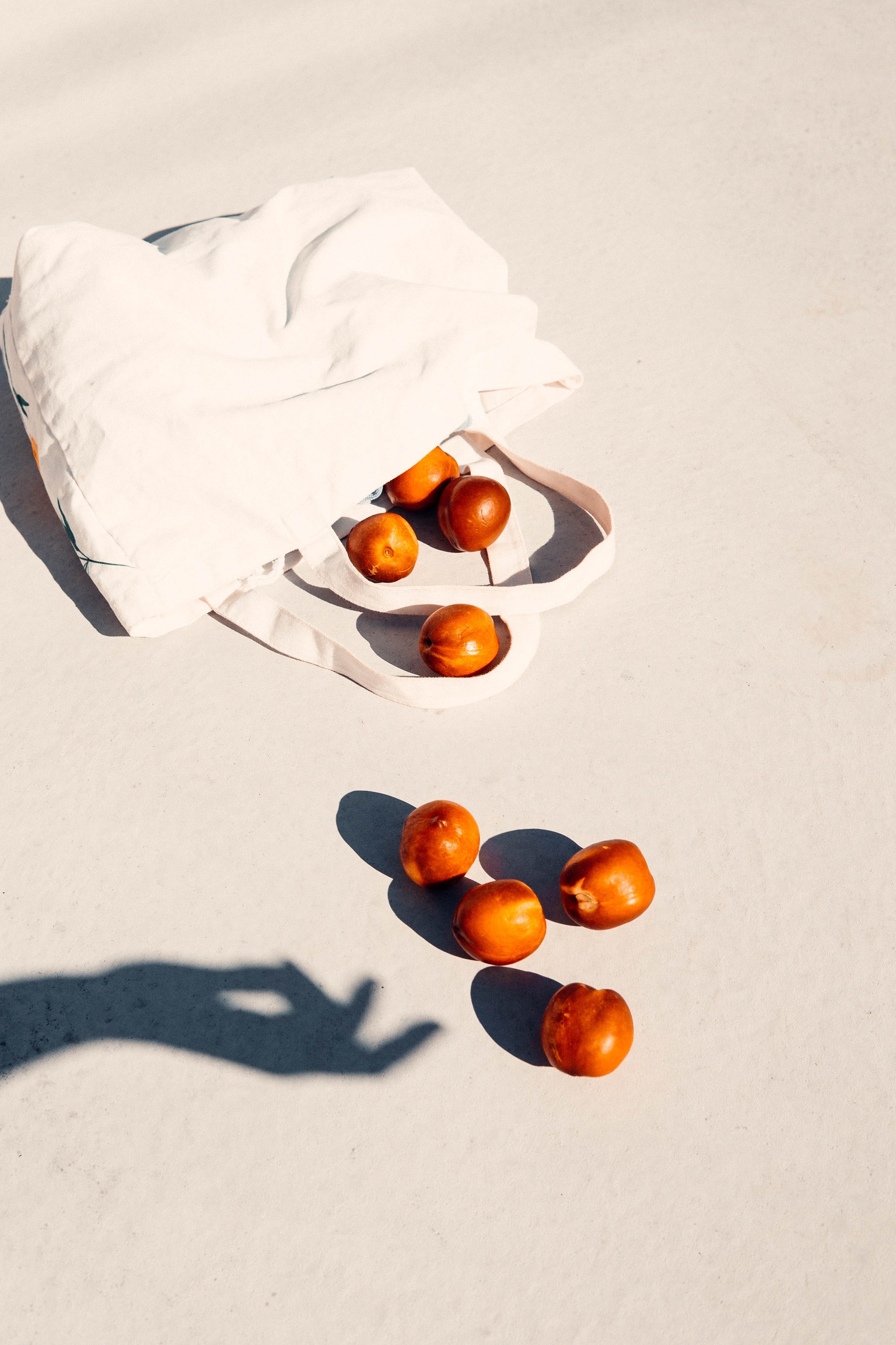 White Tote Bag and Peaches on White Surface